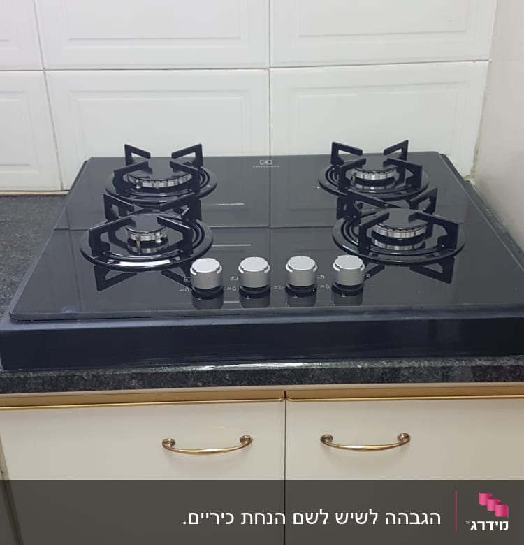 משטח שיש כהה במטבח עם כיריים גז